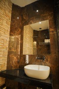a bathroom with a sink and a mirror at Hotel Ammison Inn & Suites in Amritsar