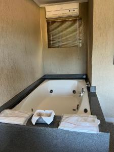 a bath tub in a bathroom with two towels at Hotel Fazenda Santa Maria in Serra Negra