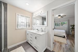 un bagno bianco con lavandino e specchio di 5B - Modern Pool - Game Room - Beachside - 7 Bed - Mural- AC - Washer Dryer a Indian Harbour Beach Altre 23 foto