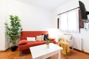a living room with a red couch and a white table at Wekey Homes, Casa del Albaicyn in Granada