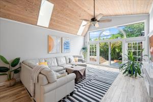 un soggiorno con un divano e un ventilatore a soffitto di 5B - Modern Pool - Game Room - Beachside - 7 Bed - Mural- AC - Washer Dryer a Indian Harbour Beach