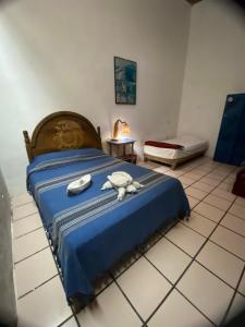 a bedroom with a blue bed with a stuffed animal on it at Hostal Luz de Luna Nuyoo in Oaxaca City
