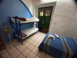 a room with two bunk beds and a door at Hostal Luz de Luna Nuyoo in Oaxaca City