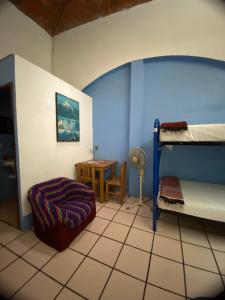 a bedroom with two bunk beds and a table at Hostal Luz de Luna Nuyoo in Oaxaca City