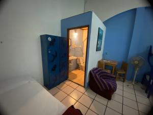 a small room with a bed and a bathroom at Hostal Luz de Luna Nuyoo in Oaxaca City