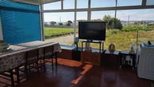 a living room with a tv and a table with a tableablish at Pensión Atlántico in Muxia