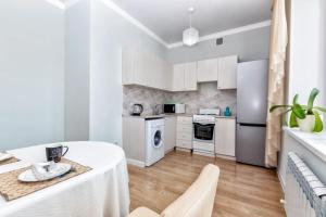 a kitchen with white cabinets and a table and chairs at Венский квартал in Prigorodnyy +4 photos