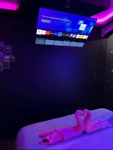 two pink flamingos laying on a bed in a room at Le Pink in Aubervilliers +10 photos