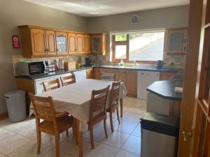 a kitchen with a table and chairs in it at Shamrock Cottage in Inch