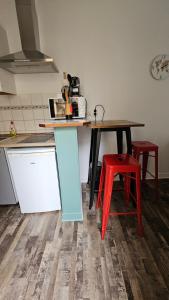 cocina con mesa y 2 taburetes rojos en Studio New York hypercentre Reims, en Reims 3 fotos más