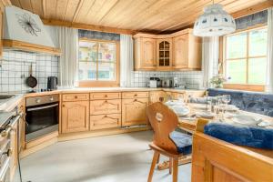 a kitchen with wooden cabinets and a dining table at Panorama Chalet Höllmaishof in Bischofshofen +47 photos