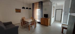 a living room with a table and chairs and a television at Casamia in Follonica