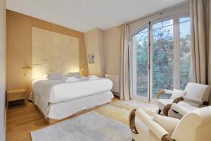 a bedroom with a bed and a large window at Fabulous House - a Gem in Chic Western Paris in Paris