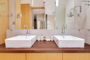 a bathroom with two white sinks and a mirror at Fabulous House - a Gem in Chic Western Paris in Paris