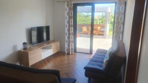 a living room with a tv and a couch at The confidence in Mahébourg