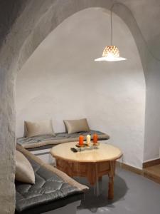 a living room with a table and a couch at Encantadora casa-CUEVA en pleno barrio alfarero de Nijar in Níjar