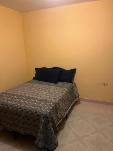 a bedroom with a bed with a pillow on it at Casa Socorro in Tala