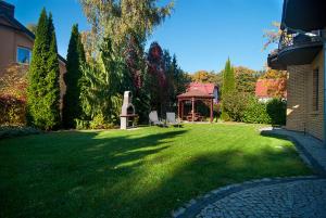 a green yard with a gazebo in a house at Willa Bursztynowa 3 in Poddąbie