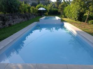 a swimming pool with blue water in a backyard at Casas do Eido e Casa da Viúva in Celorico de Basto