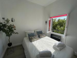 a bedroom with a white bed and a window at Les Allées Provençales in Montélimar