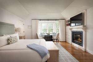 a white room with a bed and a fireplace at Chatham Bars Inn in Chatham
