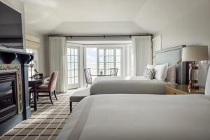 a hotel room with two beds and a desk at Chatham Bars Inn in Chatham