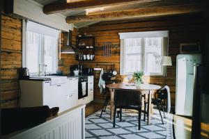 a kitchen with a table and a kitchen with wooden walls at Villa Aatos in Jyväskylä