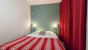 sypialnia z łóżkiem z czerwoną zasłoną w obiekcie Appartement cosy 1 chambre 4 pers face pistes 08 w mieście LʼHuez