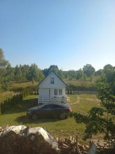 a car parked in front of a small house at Domek u Beaty 1 in Rewal +4 photos