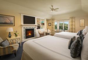 a hotel room with two beds and a fireplace at Chatham Bars Inn in Chatham
