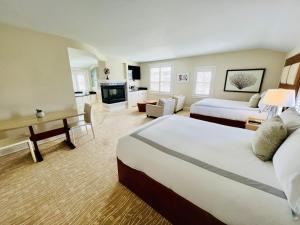 a large hotel room with two beds and a living room at Chatham Bars Inn in Chatham
