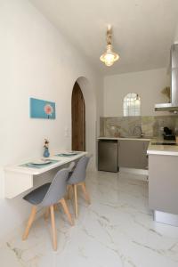 a kitchen with a table and chairs in a room at V&D Paleokastritsa Apartments in Lákones