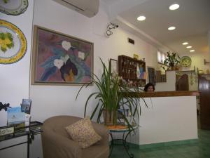 イスキアにあるHotel Villa Verdeの椅子と植物のあるテーブルが備わる部屋