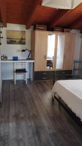 a bedroom with a bed and a desk and cabinets at Mansarda al mare in Pertegada