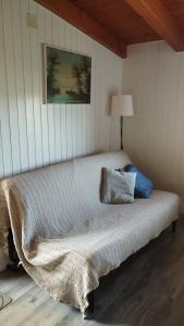 a bed sitting in a room with a lamp at Mansarda al mare in Pertegada