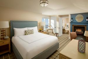 a bedroom with a bed and a living room with a fireplace at Chatham Bars Inn in Chatham