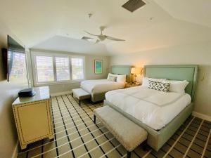 a bedroom with two beds and a chair in it at Chatham Bars Inn in Chatham