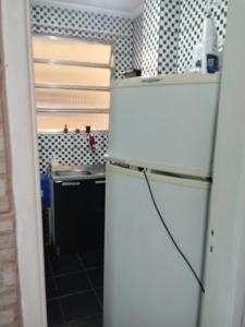 a white refrigerator in a kitchen with a sink at APMartinsjreige in São Vicente