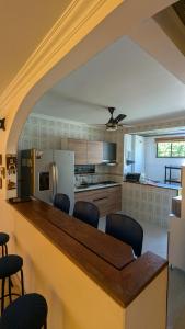 a kitchen with a counter with chairs and a refrigerator at Casa del Sol in Carmen de Apicalá