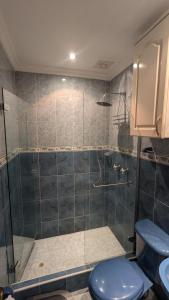 a bathroom with a shower with a blue toilet at Casa del Sol in Carmen de Apicalá