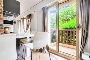 a kitchen with a table and chairs and a large window at Résidence Castel St Clair - maeva Home - Appartement avec terrasse 2 Pièces 4 personnes - Confort - super Home MAE-6371 in Deauville