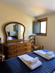 a bedroom with a bed with a dresser and a mirror at Casa Dentro da Vila in Ponte de Lima +28 photos