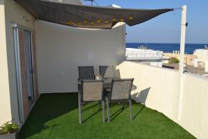 a patio with a table and chairs on a balcony at Kuburno Roof in Kos Town