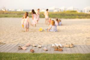 a group of people on the beach with pairs of shoes at Chatham Bars Inn in Chatham