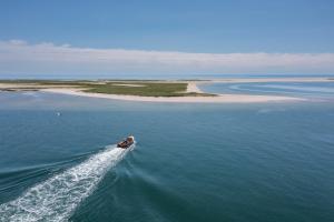 a boat in the water with an island in the distance at Chatham Bars Inn in Chatham