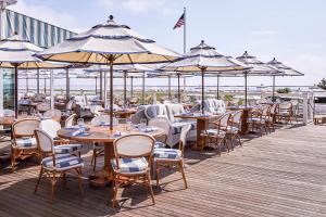 a row of tables and chairs with umbrellas on a deck at Chatham Bars Inn in Chatham