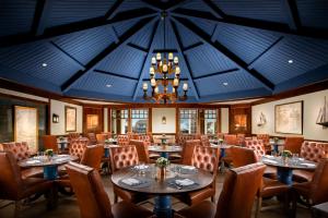 a dining room with tables and chairs and a chandelier at Chatham Bars Inn in Chatham