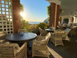a patio with tables and chairs with the ocean in the background at Chatham Bars Inn in Chatham