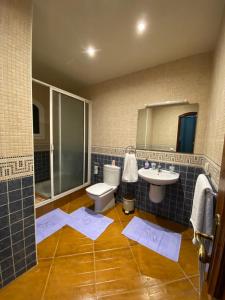 ein Badezimmer mit Toilette, Waschbecken und Spiegel in der Unterkunft Oasis balnéaire en bord de mer à 200m de la plage et à 10 min de Taghazout in Agadir nʼ Aït Sa + 37 Fotos