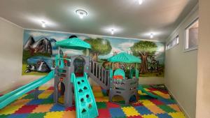 a play room with a slide and a mural at Hotel Restaurante Boitupesca in Boituva